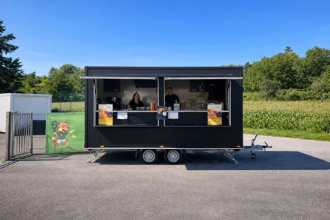 Zwei Teammitglieder an der geöffneten Ausgabe von Zülfis Foodtruck