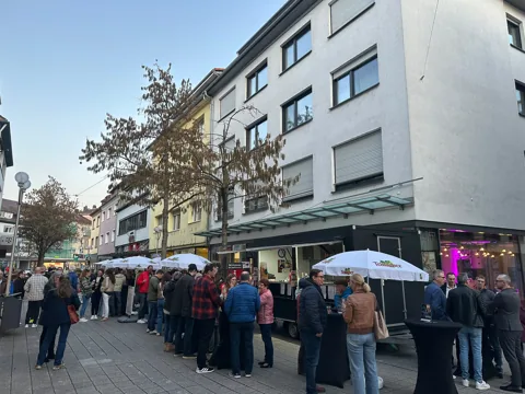 Gäste an Stehtischen bei einer Veranstaltung in der Innenstadt