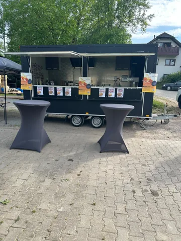Geöffneter Catering-Anhänger mit Stehtisch und Getränkekühlschrank
